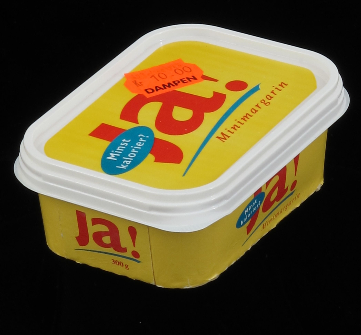 Beger av kartong, med lokk av plast. Lokk og boks er påtrykt farget  dekor, varemerke og vareopplysninger, samt strekkode. Underlokk av papir mangler, var lufttett dekke for matvaren. Pakning på  300g.  Tilstand: God.
