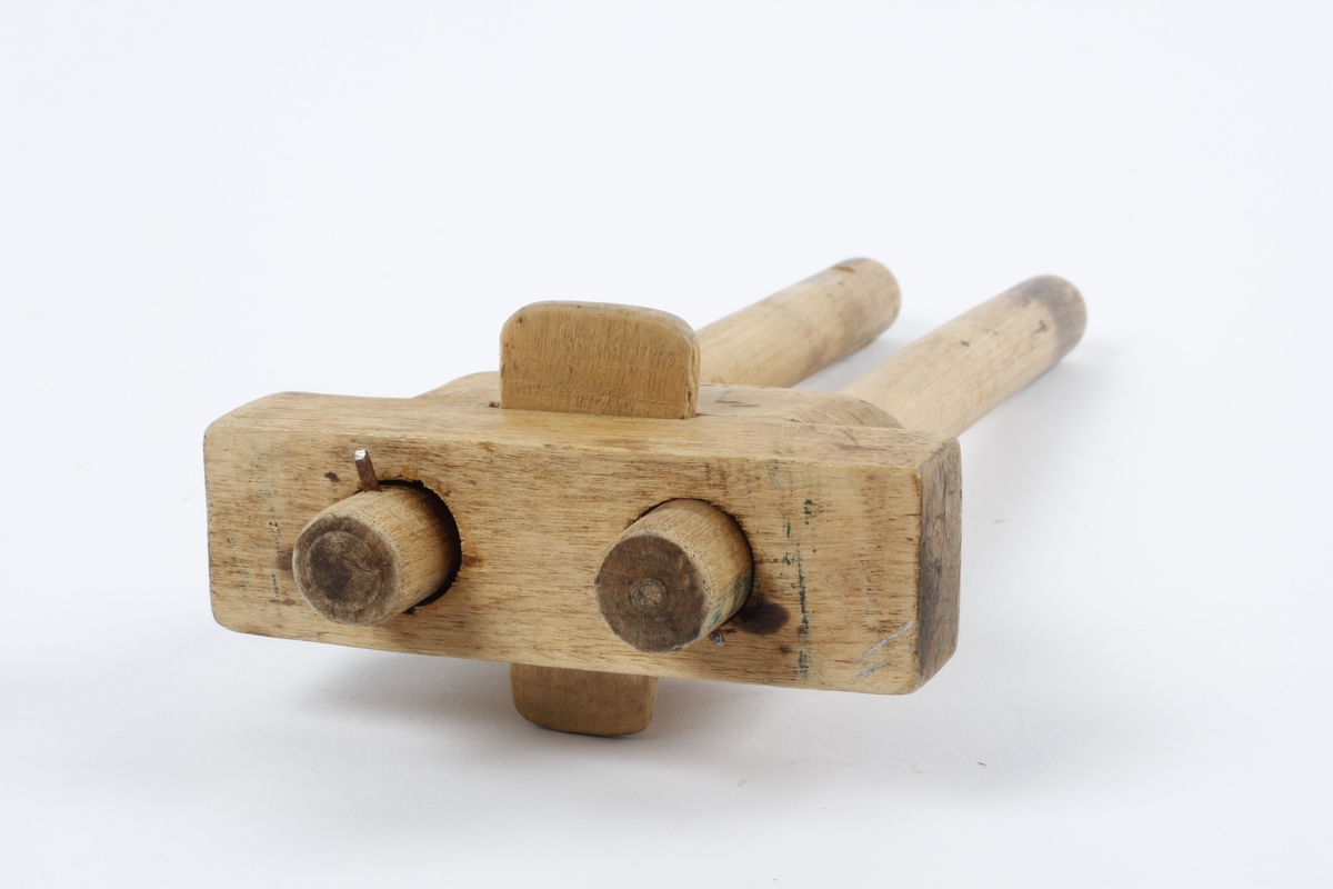 Et stykke med to hol. Gjennom hola to bevegelige, runde pinner med stift til å risse streker med. Trapesformet stykke gjennom hovedstykket mellom pinnene Tidl. reg.:"Strek-mott,  laget av skredder Kristian Braaten (far til O. Braaten) Sløydlærer Pastor Lars Hofgaard"