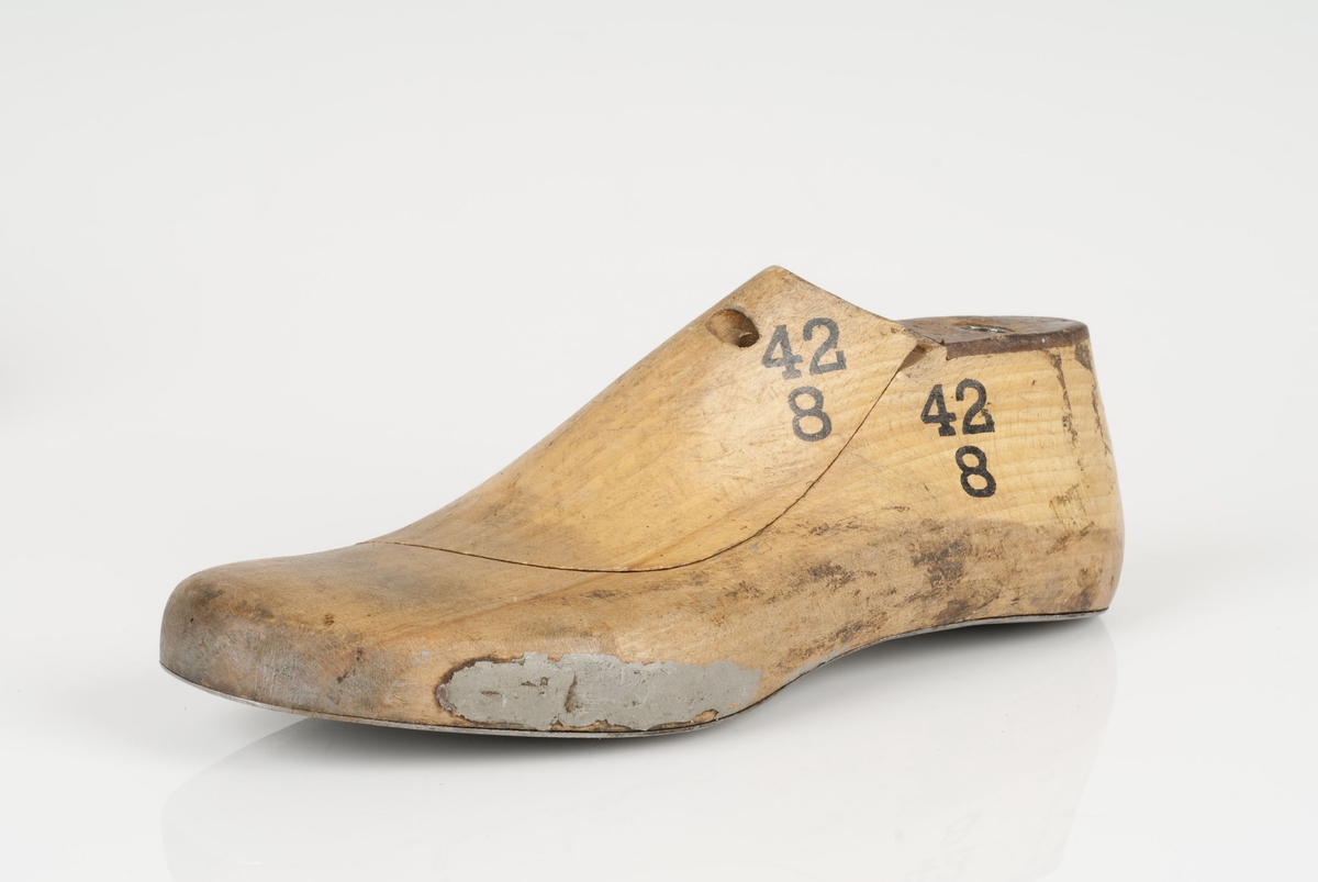 En tremodell i to deler; lest og opplest/overlest (kile).
Venstrefot i skostørrelse 42, og 8 cm i vidde.
Såle i metall.