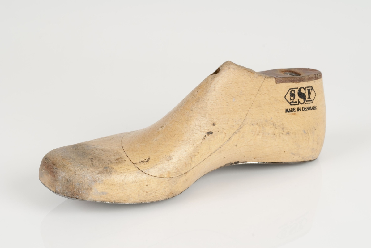 En tremodell i to deler; lest og opplest/overlest (kile).
Høyrefot i skostørrelse 36, og 8 cm i vidde.
Lestekam i skinn.
Såle i metall.