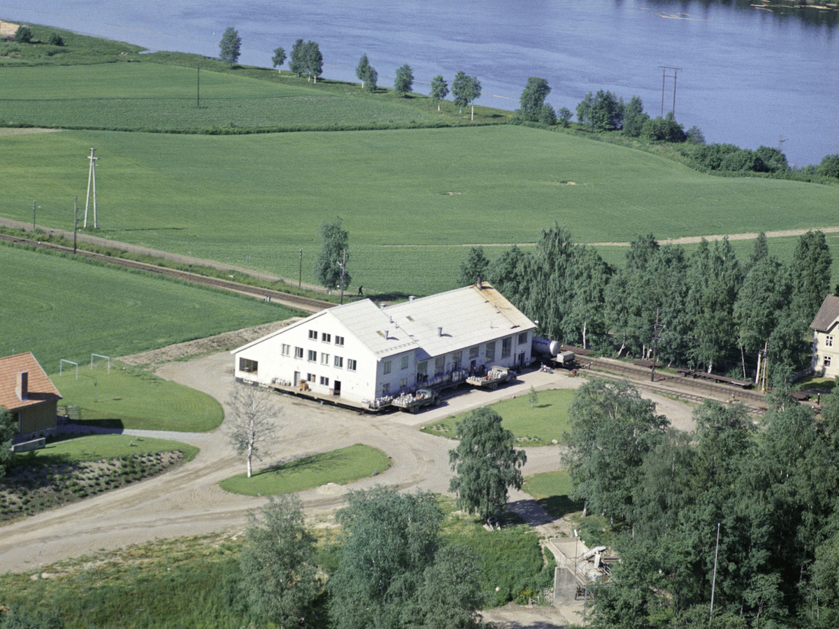 ÅRNES MEIERI. Lastebiler med melkespann ved rampa. På Baksiden av huset stopper toget.