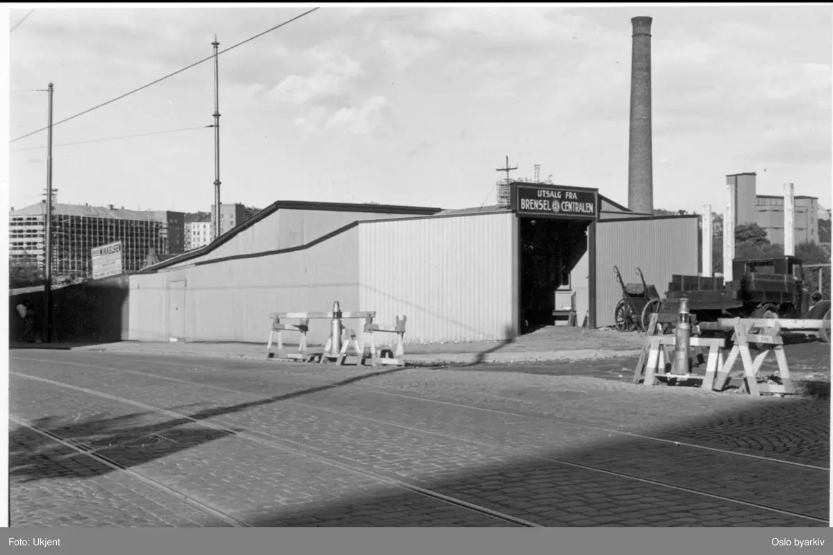 Brødrene Mikkelsens bilverksted og utsalg fra Brenselcentralen i Bentsebrugata 15/17. Trikkelinje. Lastebil og kjerre. Fabrikkpipe på tidligere Bentse Brug i bakgrunnen.
