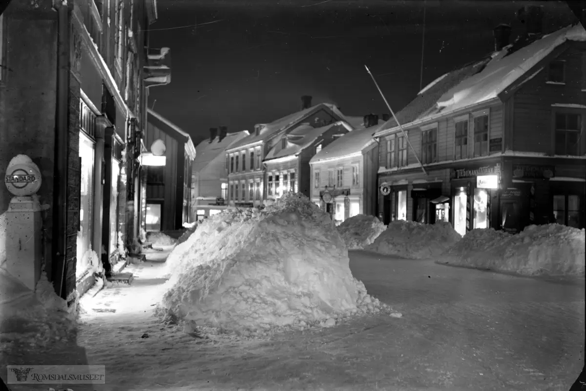 Storgata sett vestover, Storgata sett østover fra Elvsaas til venstre og deretter Strande. Til høyre Nustad, Lund, bokhandler Olaf Sættem og Isachsengården.