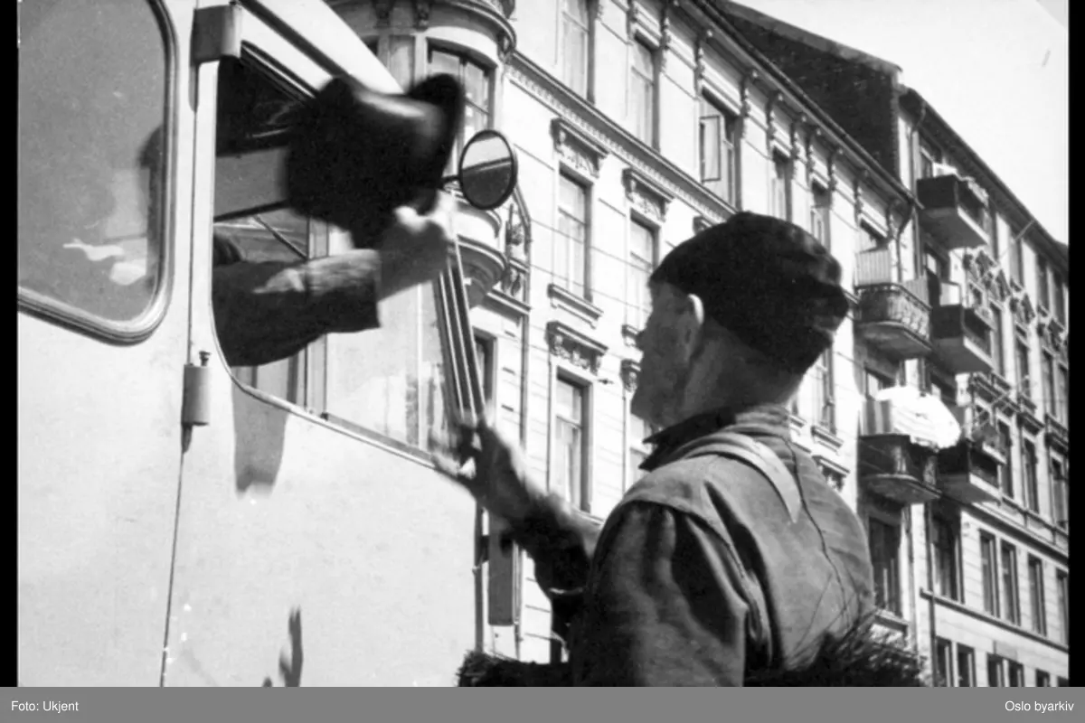 Renovasjonsarbeider ved bil, passasjer kaster flosshatt ut av bilvindu.Bildet er tatt i forbindelse med filminnspillingen av "Rehnholdsverket" (1952, regissør Finn Carlsby), en film produsert av Oslo kinematografer A/S og del av prosjektet Oslofilm. Les mer om Oslofilmer på http://www.byarkivet.oslo.kommune.no/film/