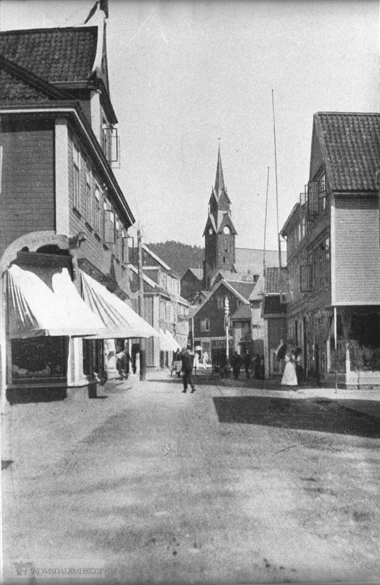 Storgata sett østover. Bildet er hentet fra Harold Simpson: Rambles in Norway (1912) s. 160 .Ludvig Hansen sin butikk nærmest til venstre.