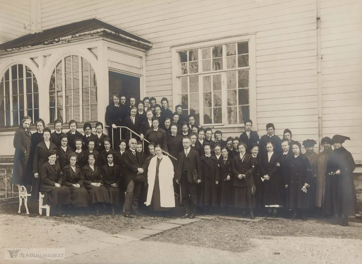 Reknes sanatorium..Dette bildet er etter Anne Marie Hatle g.Mahle f.07.03.1889. Hun står i bakerste rekke til venstre, nr.5..Hun var ferdig sykepleier ca 1918. (hadde spanska på Nasjonalforeningens sykepleierskole, Vang på Hedemarken..Var første sykepleier i gamle Fræna, påkostet av Indre Fræna sykelpeieforening. Bildet er tatt på Reknes, hvor det var kurs. Søstre fra flere organisasjoner..Sjukehusmuseet har fått bildet av Anne Maries datter, sykepleier Åse Mahle g.Kyllo. Hun vet ikke når bildet er tatt men overlege Folkestad er der og hun kom til Reknes i 1923..Anne Marie var sykepleier Indre Fræna 1918-høsten 1924, da hun giftet seg. Senere bestyrte hun en tid aldersheimen på Tornes.