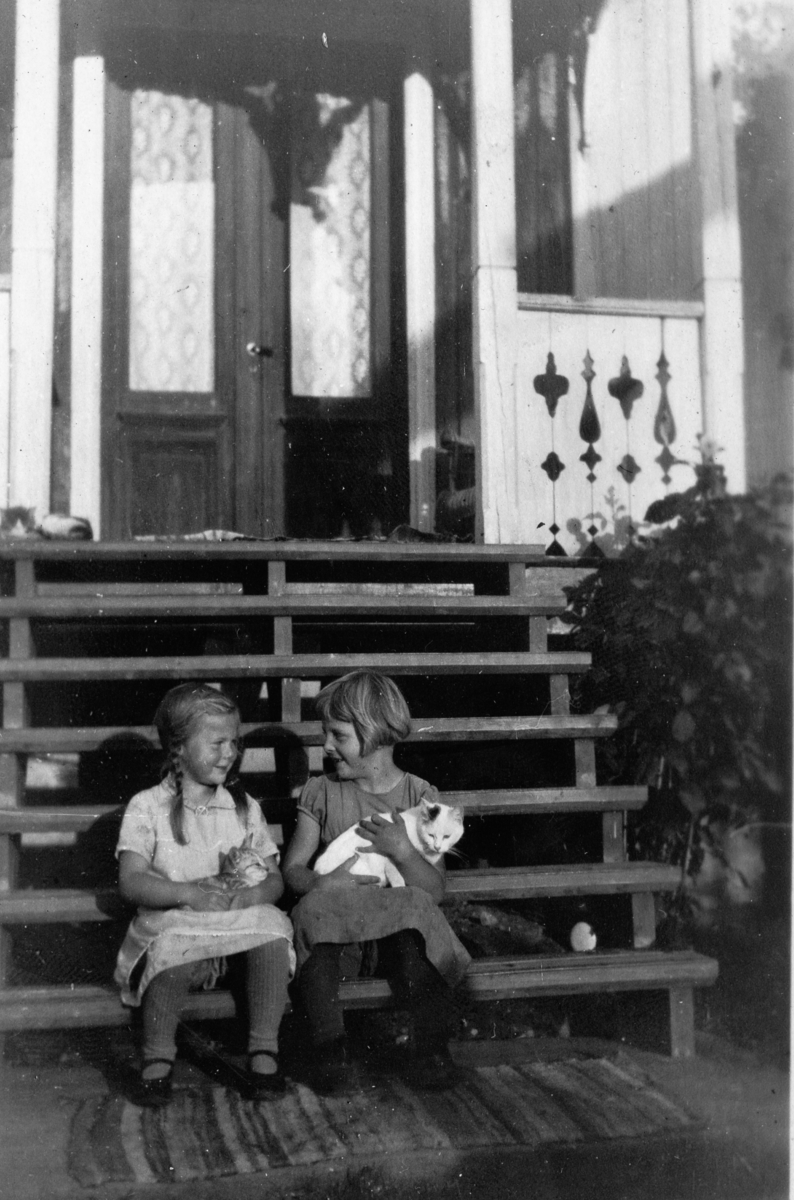 To barn på trapp,kjole og katt.
Frå v.Olaug Sørsdal og Margrethe Lunda