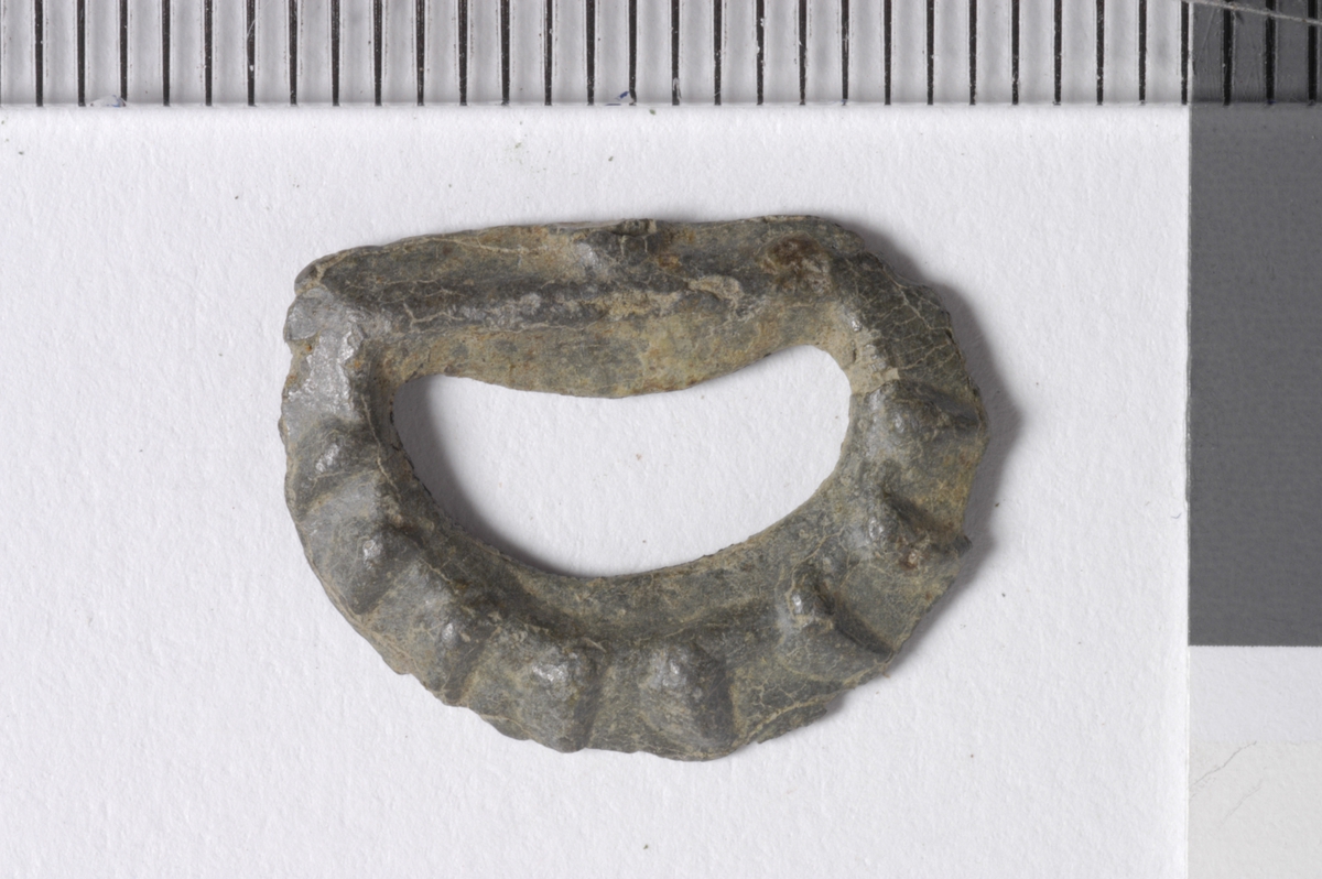 MALV: B. 17 MM, STØPT, HALVSIRKEL. DEN ENE SIDEN HAR RADIALE RIFLER. DEN ANDRE SIDEN ER FLAT. LIGGER SAMMEN MED BESLAG. BELTE. 