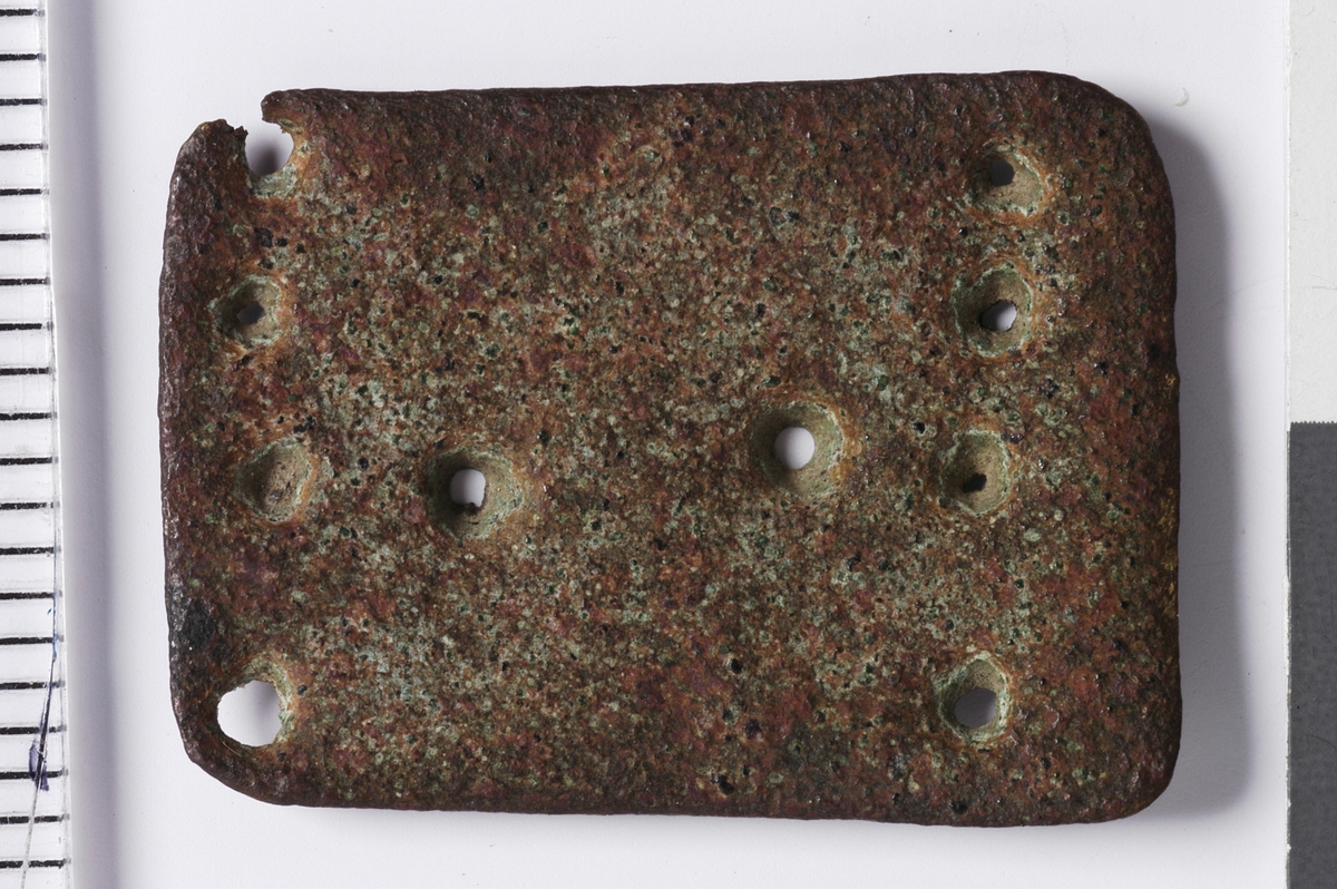 Ti punslede punkter satt opp med fire på linje i hver av kortendene og to langs midten av platen. Til sammen gir de form av en majuskel H.