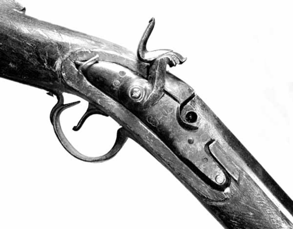 Geværet er et ombygd militærgevær. Skjeftet er laget av ubehandlet bjørk og ikke finpusset. Pipen er fra en jegerrifle med flintlås. M/1803 (Hærmuseets årbok 1960 side 212), 
På undersiden av pipa står forskjellige stempel: