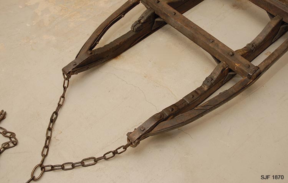 Skogsslede bestående av tre objekter (deler), 2 sleder og 1 drag. Sleden er av den typen som kalles «tømmerrustning» eller «bukk og geit», hvor den fremste sleden kaltes bukk og den bakerste geit. A: Bukken har en fast bank (73 cm b) som er felt ned i to 10 cm høye dyner. Banken stikker 6 cm utenfor dynene på hver side. B: Geita har to faste banker (fastbanker) med jernbeslag i hele sin bredde. Den er felt litt ned i dynene og festet med jernbeslag. C: Dragets humul er 12 cm bredt og er festet inn i skjekene. 

Denne tømmerrustningen er en «Hadelandsdoning» som ble laget i 1912 på Hadeland. En del hadelendinger kom til Hallingdal for å kjøre tømmer i 1912-13, og giveren kjøpte denne rustningen av en av tømmerkjørerne etter at arbeidet med disse driftene var ferdige. Dette var den første Hadelandsdoningen i Hallingdal. Den er smalere og lettere enn Moelven-rustningen. Lastebredde: 90 cm.  Doningen er i god stand, giveren har pusset den opp. Alle kjettinger som hører til er med, og doningen har solide jernbeslag. 
Brukt av giveren.