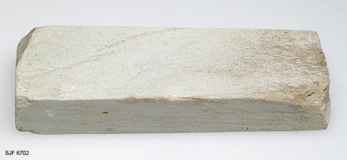 Bryne fra brynesteinsbruddet i Eidsborg i Vest-Telemark. Det er lagd av en lysegrå. finkornert sandsteinsbergart. Formen later til opprinnelig å ha vært rektangulær - 16,1 X 5,2 X 2,9 centimeter - men det er slått vekk noen skår i to av hjørnene. 

Slike bryner var en stor salgsartikkel fra den lille Eidsborggrenda Et parti ble innkjøpt for videre salg i museet.  Form: Rektangulær