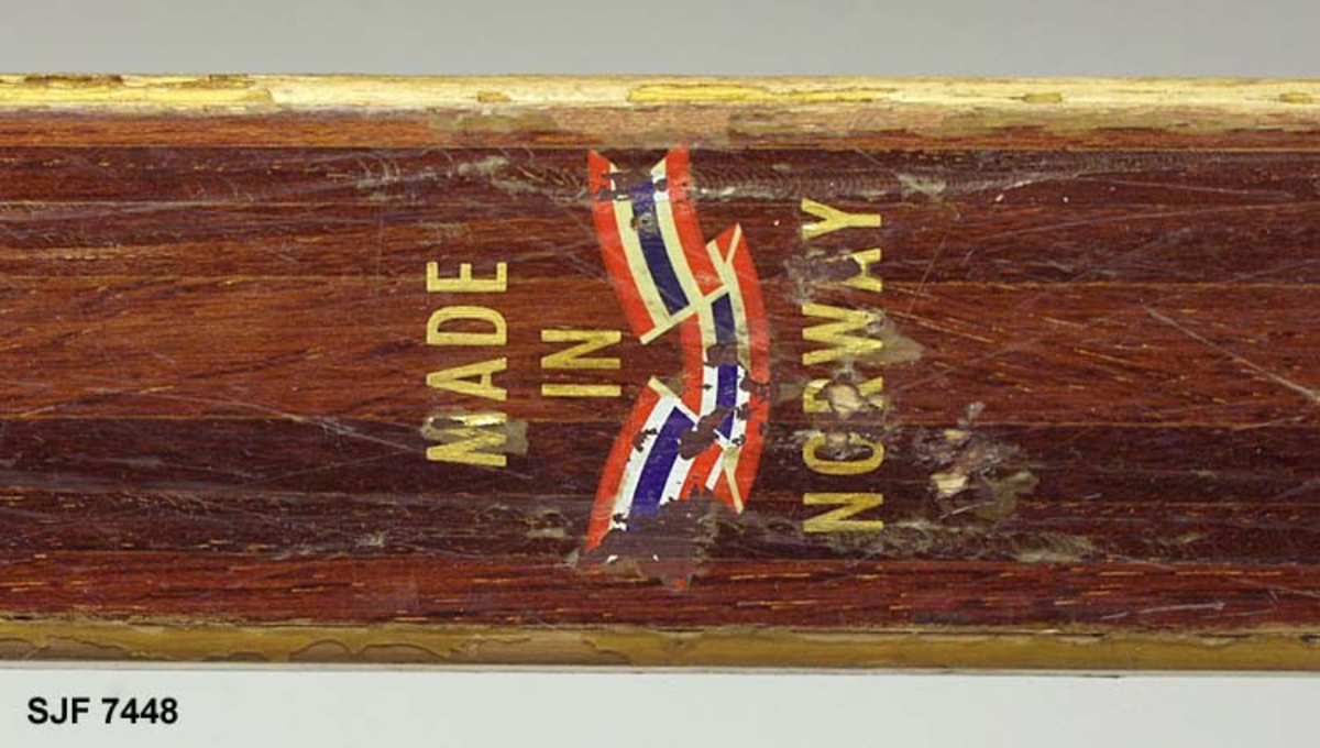 Enkelt turlangrennski uten binding. Skia er 208 centimeter lang. Bredden fremst, der kurven mot tuppen starter, er 5,9 centimeter. Ved bindingsstedet er bredden 4,9 centimeter. Bakerst er bredden 5,5 centimeter. Skia er med andre ord noe innsvingt (konkav) i lengderetningen. Tjukkelsen der hvor kurven mot tuppen starter er 0,6 centimeter. På midten, der hvor bindinga skulle monteres, er tjukkelsen 2,5 centimeter. I den bakre enden, som er noe oppsvingt, er tjukkelsen om lag 0,7 centimeter, cirka 5 centimeter framfor endebeslaget. Langs midtaksen på undersida (sålen) er det høvlet ei styrerand, en cirka 1,0 centimeter bred hulkil. Langsmed sålens ytterkanter har skia 6-7 millimeter brede hardvedkanter, lagd av lignostone, bøkeved som er presset under høyt trykk, og som her framstår som mørkere enn det øvrige treverket i skiene. Oversida av skia er brunlakkert, med unntak av smale faser langs sidekantene, Giveren mener at dette er ei «Toppen-ski» fra Gjøvik skifabrikk, men et klistremerke med en innringet «K» kan peke i andre retninger. Bakskiene er merket med et klistremerke der det står «MADE IN NORWAY». Framfor bindingsfestet er sifrene «210» (skilengden) og «2563» (muligens et priduksjonsnummer) innstemplet.