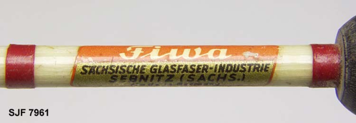 Denne fluestanga er blitt kjøpt ved Heradsbygd Samvirkelag ca. 1970, som har sitt eget merke på stanga. Stanga har et velformet korkhåndtak med sort, patinert glidebeslag for snella. Snella er ei flue- og marksnelle av messing, med utskiftbarklikk, balansehåndtak, slik at den også kan brukes som kastesluksnelle. Det står også skrevet "SEBNITZ (sachs. ) made in Germany" på snella. 
