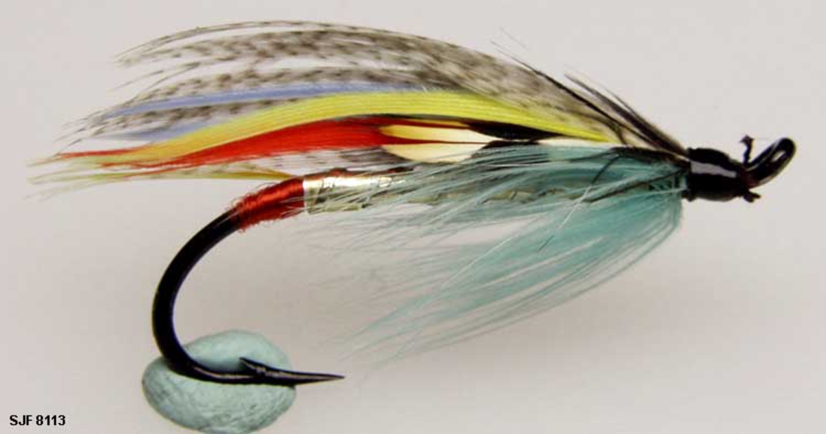 Lakseflue med sort krok og oval tråd, den har også et oppadbøyd øye. 