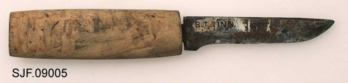 Tollekniv uten slire, lagd og brukt av smeden Svein Svimbil (1888-1987) fra Tinn Austbygd i Vest-Telemark. Kniven er 18,5 centimeter lang. Knivbladet utgjør 8,6 centimeter av dette lengdemålet. Bladet er snaut 2,0 centimeter bredt bakerst ved brystningen, men egglinja er slipt såpass mange ganger at bladbredden på midten er bare drøyt 1,5 centimeter. Bladtjukkelsen er om lag 4 millimeter ved brystningen, men bladet tynnes gradvis framover mot knivspissen. Bladryggen er forholdsvis rett, riktignok en aning nedoverskrådd i den fremre enden, der sidekantene er avfasete. Smeden har plassert stempelet sitt - «S.T. TINN» bakerst på det som når kniven holdes i arbeidsstilling er høyre bladside. De nevnte initialene refererer til Svein Tverberg, som var det navnet smeden brukte før han kjøpte småbruket Svimbil.