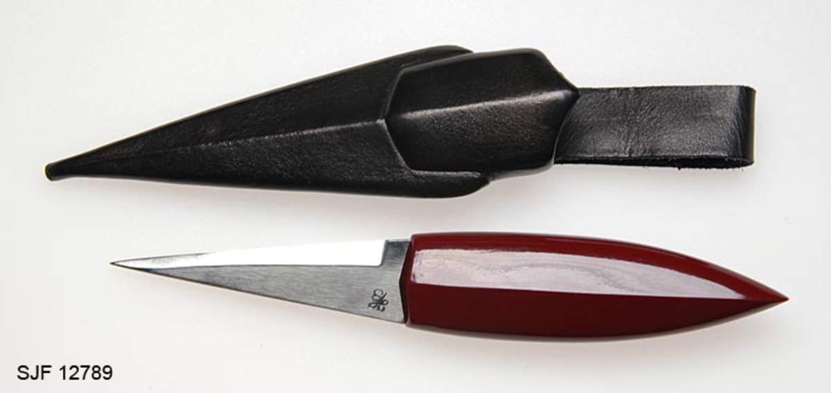 Tollekniv med slire.  Bladet er smidd av Håvard Bergland.  Det er forholdsvis kort (7,5 cm) og er slipt i en spiss, triangulær form og glattpolert.  Knivsmedens stempel - initialene «HB» - er innhamret på høyre side av bladet, bakerst. 

Skaftet er utført i plommetre.  Det er rett og har en konveks form, med spiss avslutning i øverenden.  Sett fra flatsidene kan formen på skaftet minne om skroget på en plattgattet båt (baugen i øverenden, akterenden mot knivbladet.  Skaftet har ingen form for holker eller beslag.  Det som sies å være spesielt med Inge Stabels kniver er lakkarbeidet på skaftet.  I dette tilfellet har skaftet en rødbrun farge, og finishen er meget glatt og blank.  Det sies at Stabel sprøtelakkerer knivskaftene sine i mange lag, etter samme prinsipp som billakkerere utfører sitt arbeid. 

Slira er sydd i svart lær.  Også den har en rett form.  Den holdes ihop av en horisontal søm på baksida.  Formen på slira gjenspeiler formen på kniven.  Det er et markert, preget skille mellom den delen som skal dekke det spisse, triangulære bladet og den øvre delen, som skal dekke skaftet, med sin markerte «midtkjøl» på begge flatsidene.  På baksida av sliremunningen er det påsydd en beltestropp, også den av svart lær, med et knapphull på baksida.  Nedenfor stroppen, til høyre for sliresømmen, har Inge Stabel preget inn et symbol, antakelig initialene hans - «IS» - stilt oppå hverandre slik at det ser ut som et speilvendt dollartegn.