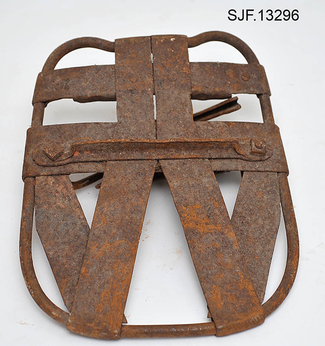 Trugesett for hest, altså fire stykker.  Trugene er lagd av jern.  Rammene er lagd av rør med cirka 1,1 centimeters diameter.  Disse rørene er bøyd i tilnærmet rektangulær form, men med noen avrundete hjørner.  Hver truge er om lag 30 centimeter lang og 24,5 centimeter bred, og har dermed ei bæreflate på drøyt 700 kvadratcentimeter.  Formen holdes stabil ved hjelp av jernband som er bøyd rundt rammerørene og klinket sammen.  To slike band går på tvers av trugene (i bredderetningen) mens det i lengderetningen er lagt band i M- eller W-mønster (avhengig av hvilken veg trugene holdes, M hvis de betraktes skrått bakfra).  De bakerste tverrbandene har kanter som er bøyd oppover, antakelig for å kunne tjene som anlegg for hakene på skogshestens vintersko.  Gjennom de brede tverrbandene noe lengre fram på trugene er det ført jernører med gjennombrutte hull for hengslingslekker for bøyler som ble lagt over hornveggene på hestens framføtter. Den ene bøylehalvdelen har T-formet tverrsnitt med hakk i overkant og lærfôringer på undersida (festet med ståltråd). Ei truge mangler slik fôring, de andre er stive og sprø etter mange års tørk uten tilførsel av nye fettstoffer. Den andre halvdelen av bøylemekanismen består av en lang, buet kjettinglekk med ei dreibar klype med ei gjennomgående nagle like bak hengslingspunktet. Denne nagla føres ned i ett av hakkene på ryggen av den andre bøylehalvdelen, hvoretter endeleddet presses ned. Dermed låses truga godt til foten på hesten. Under tverrbandene bøylene er festet i er det montert jernstag med T-formet tverrsnitt på tvers av trugenes lengderetning. Disse komponentene skulle antakelig redusere faren for at trugene skled på vinterføre. De nevnte tverrstagene er for øvrig festet med kvadratiske muttere på endetappene av «jernørene» som bøylene på oversida av trugene er hengslet til.  På jernet kan vi se spor av oransje lakk, men fargestoffet er i ferd med å bli fortrengt av gravrust. Trugetypen later til å være en serieprodusert artikkel. De brede tverrbandene på to av trugene er merket «ØR» i prikket utførelse. Trugesettet ble levert til museet sammenbuntet med en ståltråd, antakelig slik de har vært oppbevart siden sist de var i bruk.  Ifølge siste eier, Magne Ottershagen fra Styggberget i Elverum, skal dette ha vært vinteren 1953-54.

I Sverige kalles denne trugetypen «norsktrampa», hvilket vel indikerer at det må ha vært en norsk produsent som har eksportert slike truger til nabolandet.