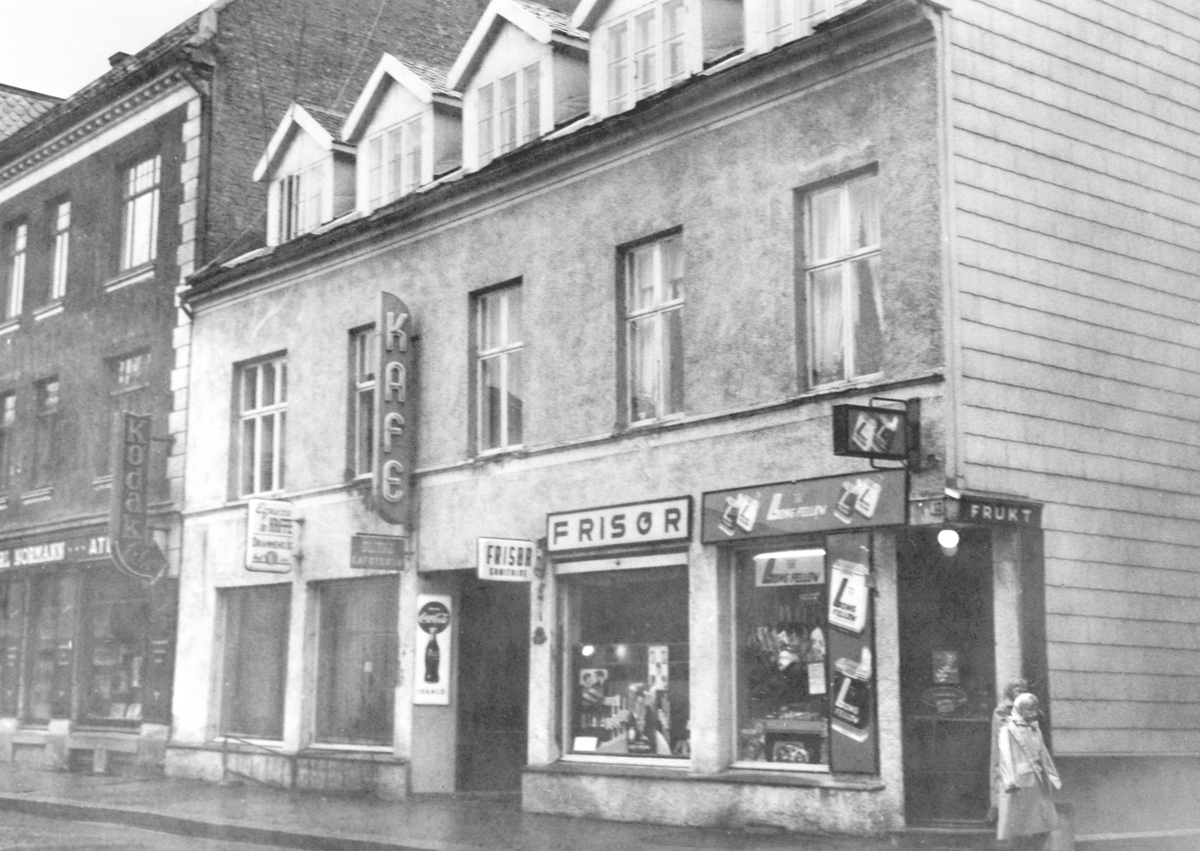 EKSTERIØR AV TORGGATA 13 FRA VENSTRE FOTOGRAF CARL NORMANNS FORRETNING, KAFE GLITNE, FRISØR OG FRUKT OG TOBAKKSFORRETNING MED SIGARETTREKLAME