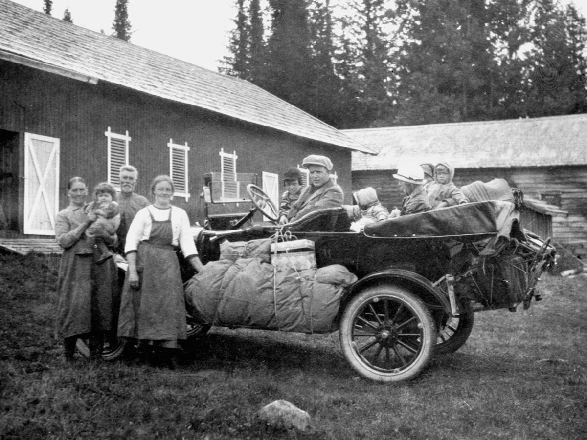 Familien Løken fra Granerud gård, Brumunddal på biltur i Ringsakerfjellet i en Ford T 1919-22 modell, D-111. Familien Harkerud tar i mot sommergjstene. Tannlege Karl Løken, barna, Alfhild Løken i baksetet.