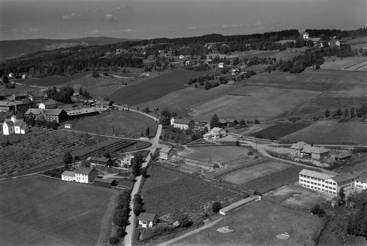 Flyfoto av Brøttum, Ringsaker med skole, gårder og kirken.