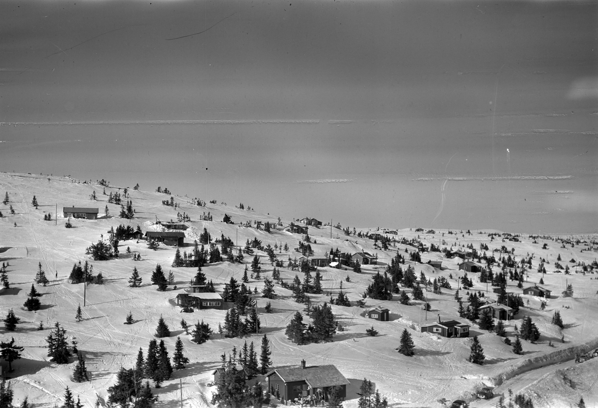 Flyfoto av bebyggelse i vinterlandskap på Sjusjøen, Ringsaker Almenning.