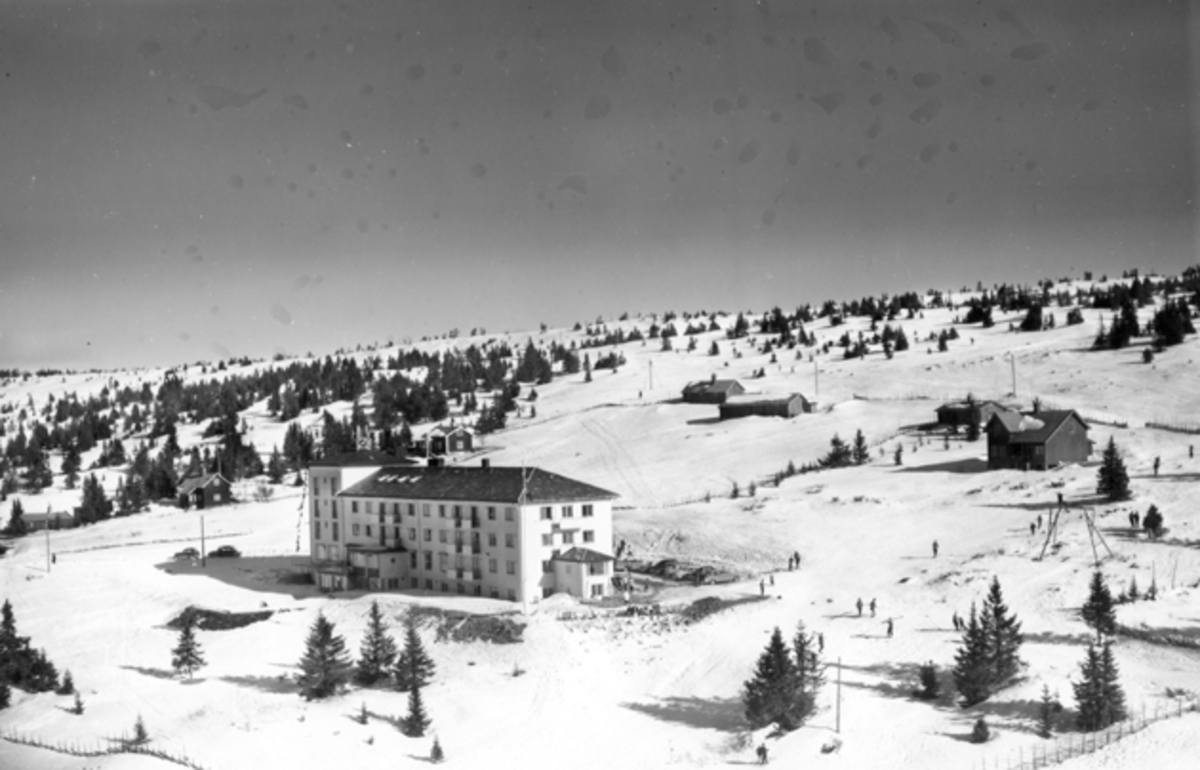 Flyfoto av bebyggelse i vinterlandskap på Sjusjøen, Ringsaker Almenning.