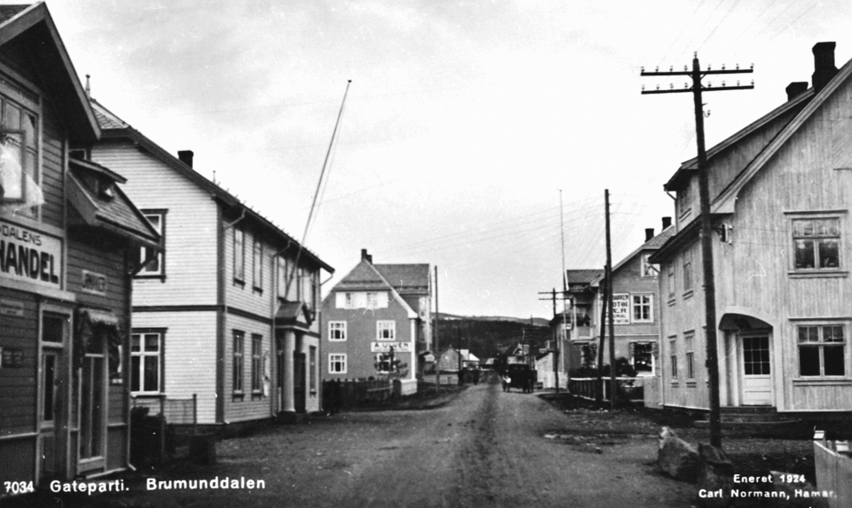 Postkort, Oversikt Nygata, Engerland, Brumunddal. Brumunddalens bokhandel, urmaker Enger, Framheim kino og forsamlingshus, Volla: A.Ulvens skotøyforretning. Til høyre er Poppely, Aker: posthus 1917-22, Søbakken, apotek.