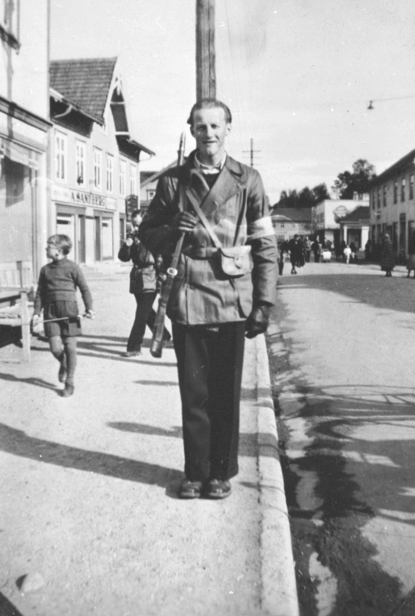 Rørlegger Asbjørn Nordsveen i hjemmefrontutstyr, på vakt langs Furnesvegen, Brumunddal, 17. mai 1945.