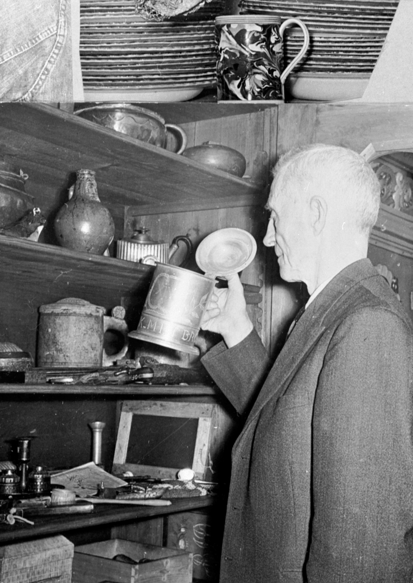 Torstein Maurud, gårdsbestyrer på Fuglseng legatgård, Ringsaker. Skap med gamle gjenstander.