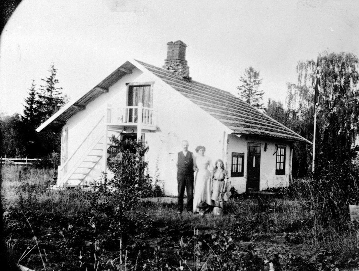 Personer utenfor Holmstøen på Hovinsholm, Helgøya. Ingeniør Fredrik Ingier f. 1872, fru Anna Ingier f. 1872 (Hoel), datter Agnes Ingier f.1902.