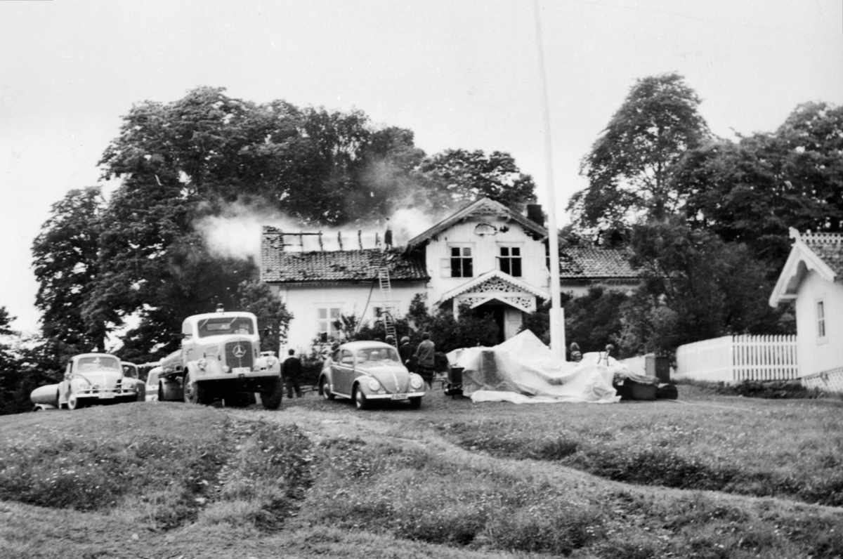 Brann i føderådsbygningen på Vinju gård, Ringsaker. brannbil, Mercedes-Benz, reg.nr. på brannbil var D-74678, 1954-modell. slukningsarbeid, mye folk. Personbiler VW. Volkswagen, folkevogn.