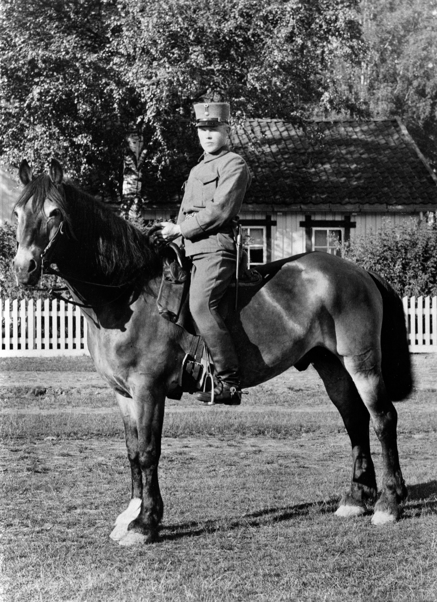 Hovslagerrekrutt Iver Jevne til hest på Gardermoen. Kvarterhesten "Leo". Kvarterhestene hadde betydning for bøndene. Hesten måtte møte opp ved innkalling. I dette tilfellet Skappel felthus. Oppdrettet på Leine Østre, 285 Leine Østre, Ringsaker Ekskadron.