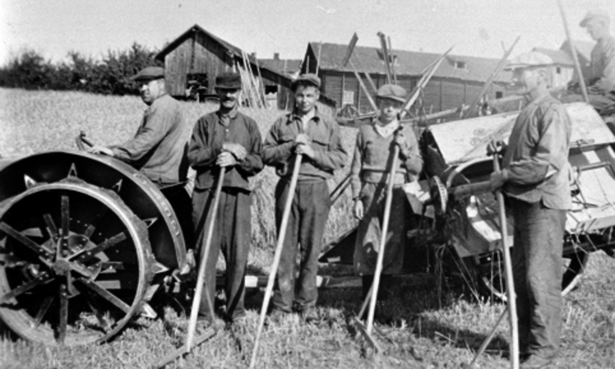 Skuronn på Mæhlum, Stavsjø, Hedmark. Case jerntraktor med selvbinder. På traktoren er Juul Gerhard Drager (1897-1974). På binderen er Magnus Roterud 1913-1985. Foran er Ansgar Magnus Dæhlen f.1886, Harald Olsen, ukjent, Johannes Drager (1865-1954).