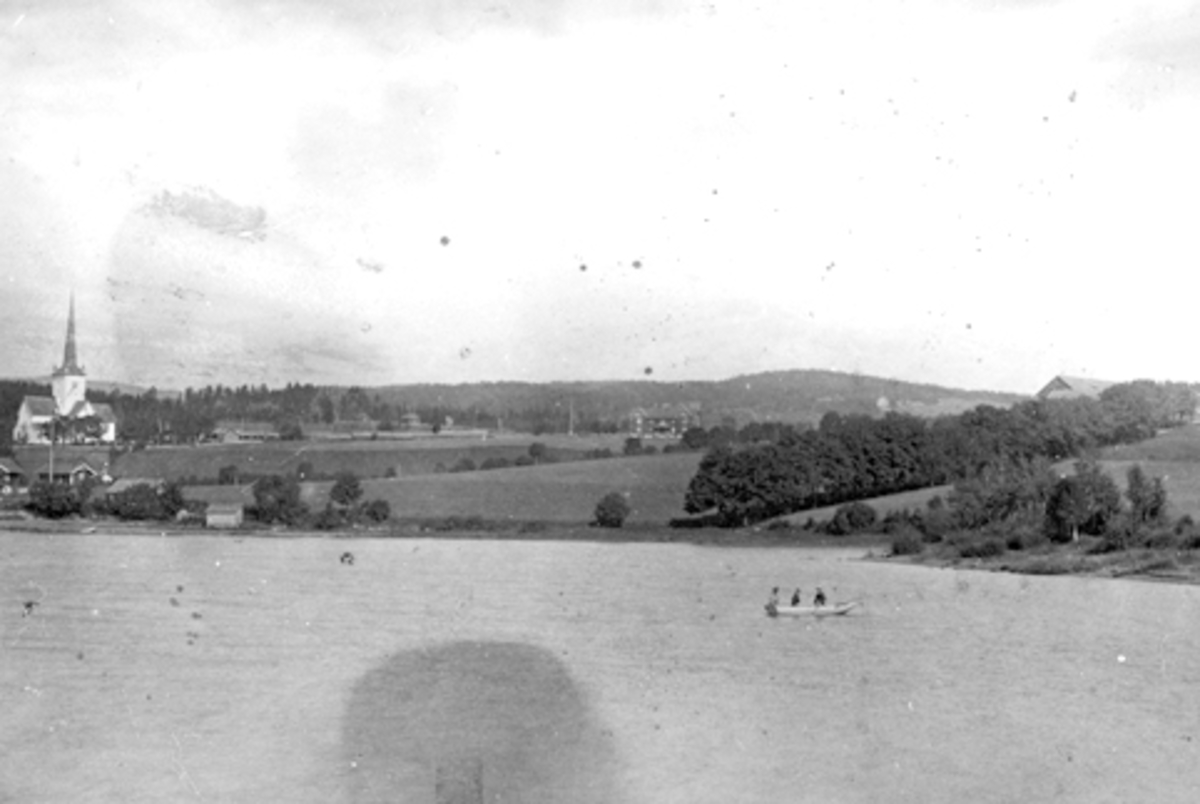 Landskap ved Ringsaker kirke, Ringstrand, Tingvang, Ringsaker lille. Robåt på Mjøsa.