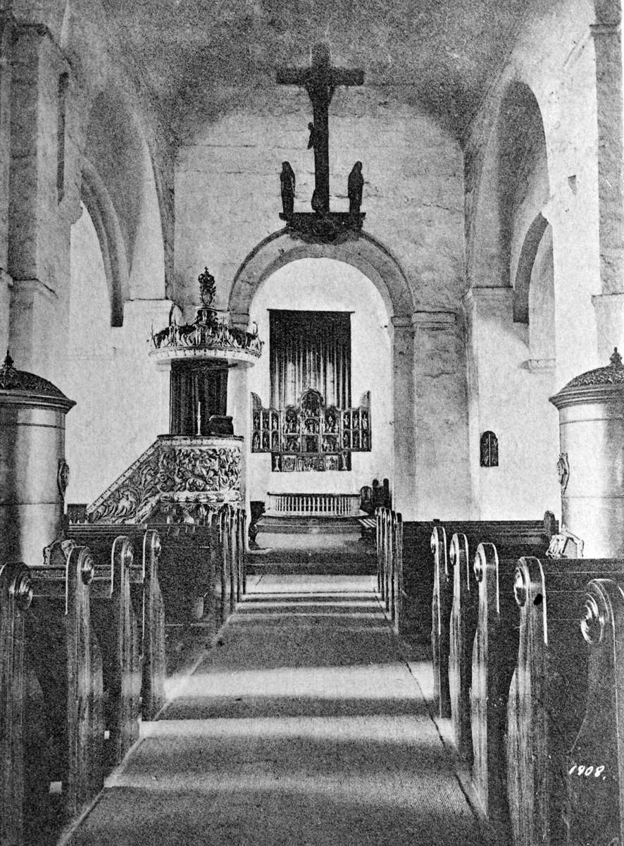 Interiør fra Ringsaker kirke ca. 1900-03. Vedovner, prekestol, altertavle, krusifiks.