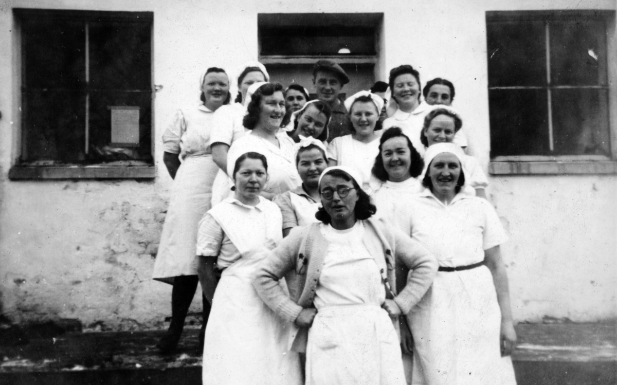 Stange meieri, "primduer" meierielever, foran Alette Hestnæs, mannen bak Magnus Moen, de øvrige ukjente. Ca. 1930. 
