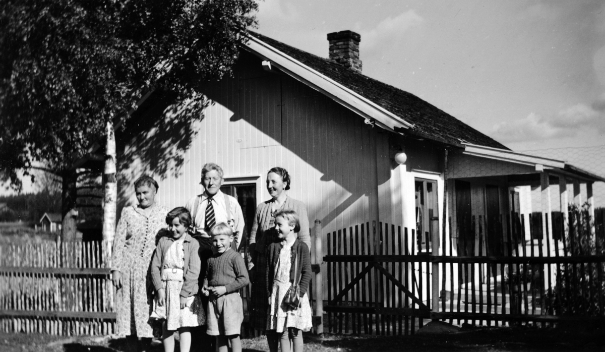 Ukjente, barn og voksne samlet utenfor hus