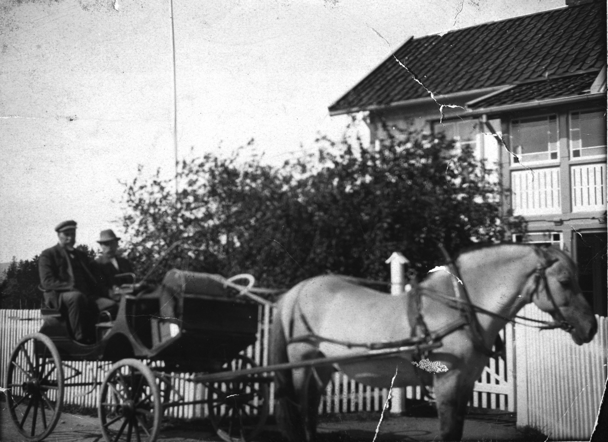 Hestekjøretøy. T. v. sitter Nils Godtland, mannen t. h er ukjent. Hesten het "Musen" og står foran et hus i Kjonerudvegen, i Bekkelaget, Stange. 