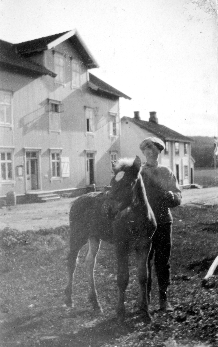 Gunnar Lundby med hest, føll, foran Lundbybutikken på Tangen. 