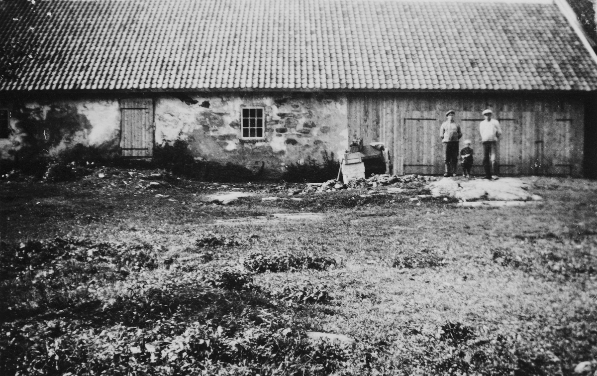 Torødegården, Tangen. F. v Gunnar Lundby, Gunvor Lundby, ukjent foran fjøset, ca. 1930. 