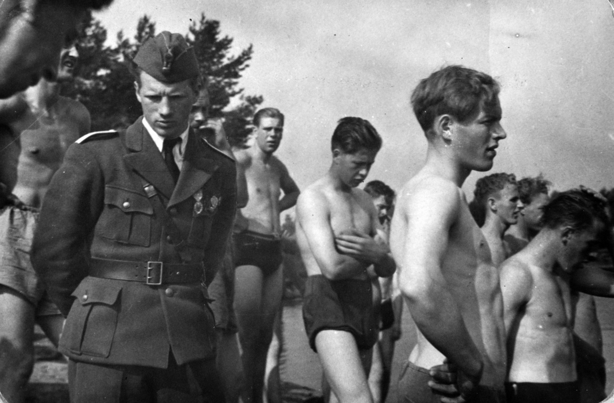 AT-tjeneste på Ådalsbruk i Løten, 26. august 1942 til 26. november 1942. Arbeidsdistrikt nr. 1. Arbeidsfylking IV. Sveit nr. 5. Forleggingssted Ådalsbruk. Arbeidstjenesten under 2. verdenskrig. 
"Utholdenhetsprøve i svømming. Klar til å stupe uti"