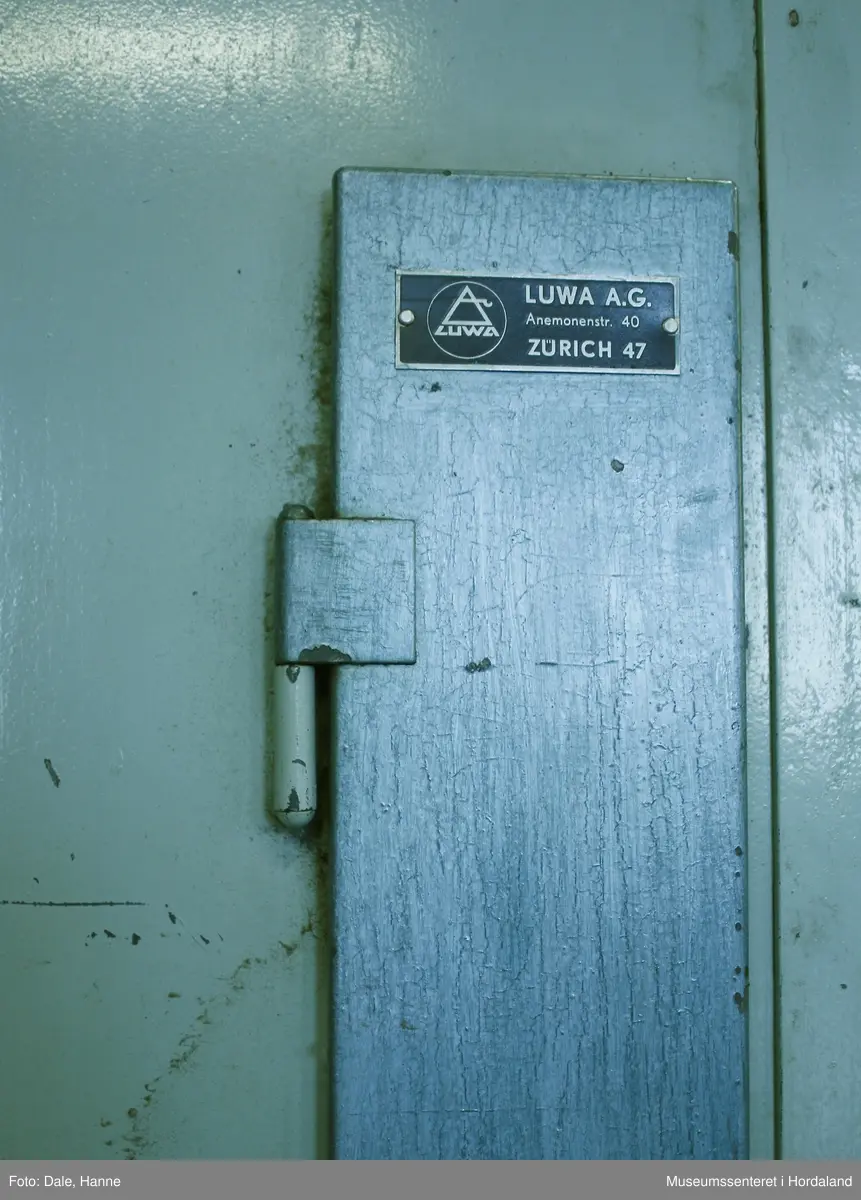 Elektrisk ringspinnemaskin (1958) frå det sveitsiske selskapet Rieter. Øvst på maskina plasserer ein spolane med forgarn frå kardemaskina. Reint teknisk er det tre hovudelement i spinninga:  forgarnet blir strukke, tvista (snodd) for å få meir styrke, før det ferdige garnet blir oppvikla på ein spole eller 'spinnepipe'. Tråden går under eit transporthjul i tre, gjennom støypte løpegangar og vidare nedover: Garnet blir snodd ved at garnet passerer ein løpar som beveger seg på ein ring, før det blir samla på ein sylindrisk metallspole. Det er ei rekkje små støvsugarar langs heile maskina, små røyr som stikk ut over spolane. Desse syg til seg støv og/eller tråden viss den ryk, for å unngå at den kjem inn i maskina. Trådrestar og støv blir samla opp i eit oppsamlingskammer på venstre sida av maskina. Der er det òg ein målar som måler kor mykje maskina spinner.

Drivverket og ein stjernemotor sit på høgre sida av maskina. På sida står det "Rieter" i raudt, og det er to målarar som måler omdreiingar/hastigheit på maskina. Det er ei rekkje med 136 koner på kvar side. Maskina kan byggjast på i seksjonar, og slik utvidast etter behov, noko som er vanleg for spinne- og spolemaskiner.