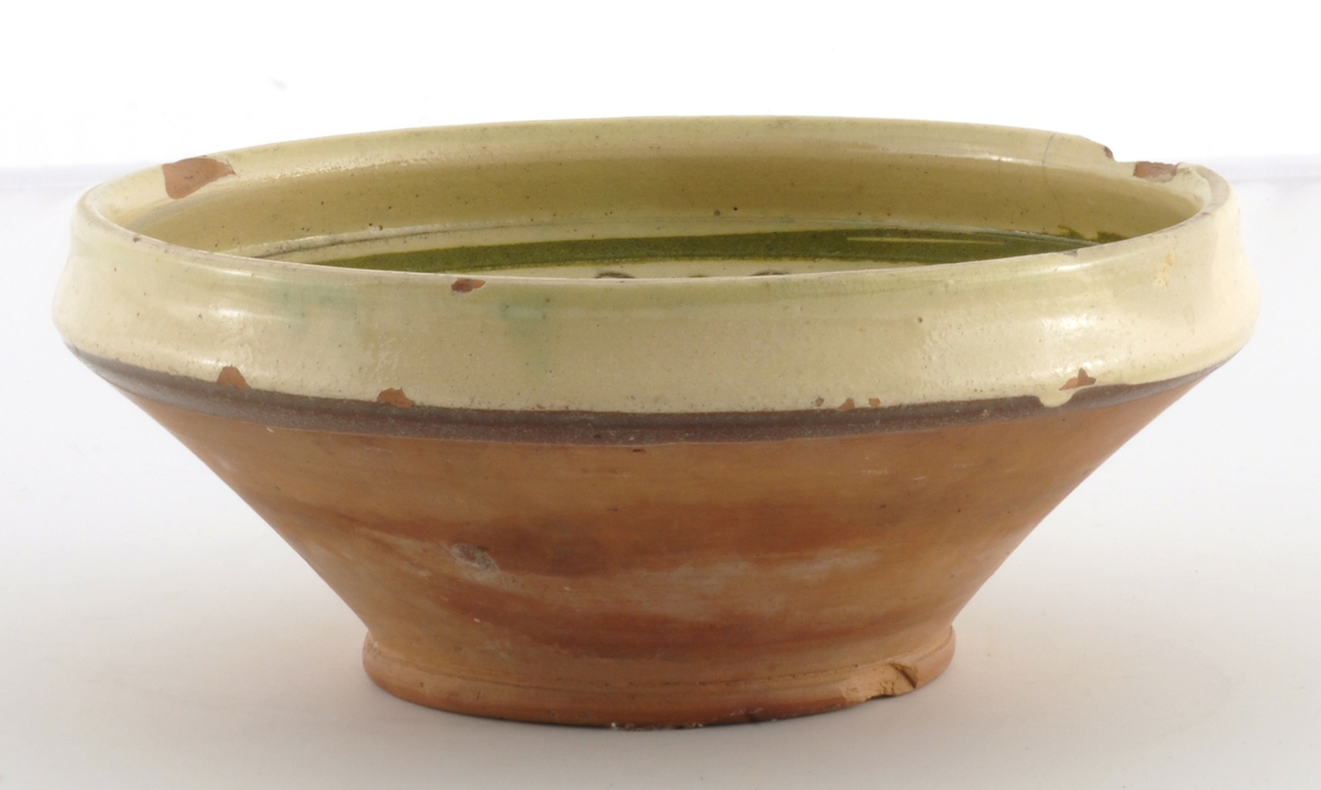 Skål med glassur innvendig og øvre del utvendig. Dekor i form av border og fugl i bunnen - risset og malt innvendig.