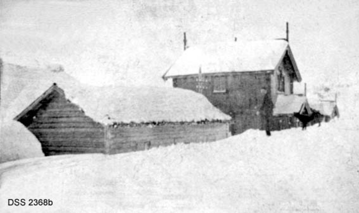 Haukeliseter fjellstue.  Seks vinteropptak, antakelig fra tida like før 1900.  A. Våningshus i djupsnø, en panelt og kvitmalt bygning til høgre, en uthusbygning og et våningshus i drakestil til venstre for dette.  B.  Uthus og våningshus i drakestil, mann med hund foran drakestilhuset.  C.  Våningshus med drakestilpreg, der særlig en toetasjes fløy til høyre i bildet har lånt trekk fra stabbur og loft i Telemark og Numedal.  D. Panelt og kvitmalt våningshus i en etasje, men med rom på loftet.  Snøen står om lag midt på veggen på forsida av huset, nestet opp til raftet på baksida.  En mann bærer noe mot inngangen.  E.  Bryggerhusliknende bygning med torvtak.  En mann ved langveggen og en i døra.  F.  11 personer foran inngangen til den kvite bygningen på fjellstua. Reinsdyrgevir over døra. 