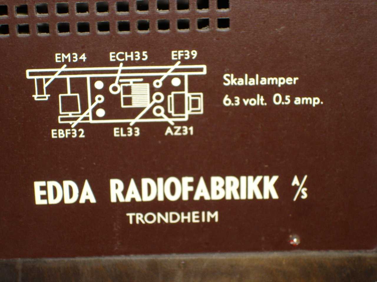 Kasse av finert tre med en tredelt underskap nede og en radioenhet oppe. Skapdelen nede består av en skapdør på hver side og en klaffdør i midten. Bak klaffedøren befinner seg en platespiller.
Grammofonen (platespilleren) er laget av Philips, modell "Stereo", og spilles med 78' plater samt med veksler til MN: type NG 3650; nr 02371.

Under platespilleren er en høytaler montert, som viser med åpningen mot tekstilavdekkingen på forsiden av klaffedøra.

Under radioenheten befinner det seg 4 hvite dreieknapper. Andre knappen fra høyre (sett forfra) viser en nummerering av hakkene sinde: L, 1, 2, 3.

Baksidig finnes det 4 forskjellige avdekkinger. To avdekkinger av kryssfiner, som er spikret bak skapene på hver side. Oppe og nede i midten er det skruet på to perforerte plater av en presset materiale. 

Inne i øvre delen befinner seg radioenheten. Den største delen av radioenheten (alle beskrivelser i dette avsnittet sett bakfra) utgjør en metallboks med flere kabler, rør etc. på, som er skruet på hylleplata under. En plate er skruet på metallboksen og i tilegg festet foran glassplata på veggen, som er synlig på forsiden av radioen. På høyre og venstre side en liten pære, som belyser glasspanele på forsiden. En større pære lyser mer eller mindre sterk, avhengig hvor sterk radiosignalet er. konstruksjon av tråd og trinser er bak glassplata og sørger for å bevege pekeren sidelengs mens det søkes signal.