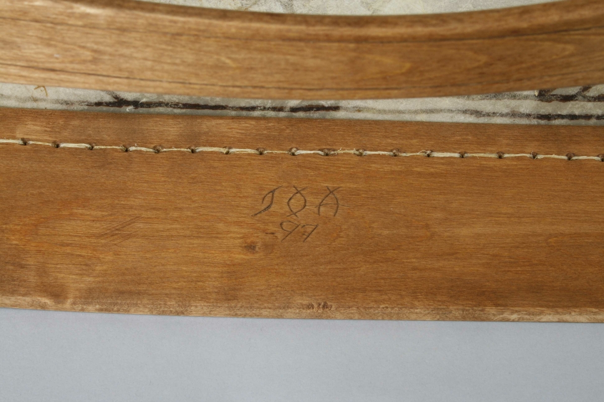 Samisk tromme av Åseletypen fra det Sør-samiske området, med malte figurer, hammer og viseren Árhpa.

Instrumentmakeren skrev i 1997:

Runebommen ble ferdig laget i slutten av oktober 1997.

Materiale.
Bjørk ble tatt i månefase NY 10 oktober. 1997. Saget høvlet og bøyd rundt en form. Tørket og bearbeidet ferdig til sying av skinn.

Skin. 
Reinskinn ble avhåret i September 1997. Skin er av en okserein 4 år gammelt.

Senetråd.
Sener er tatt av rein og spunnet på tradisjonell måte. Det er brukt både ryggsener og skanke sener til sying av skinn, Trommeskinn.

Árhpa, Runebommeviser.
Árhpa er laget av reinhorn.

Hammer.
Hammer er laget av reinhorn og av reinskinn. Det samme er også tvinnet snor.

Bark:
Fargestoff er olderbark  tatt på rota av older, tørket og malt til fint mel.
Barken er brukt til farging av selve tromme og tegn på skinn som ble blandet i vann på tre, og på skinn er det brukt Vaselinolje, ”Paraffinum Liquidum”.