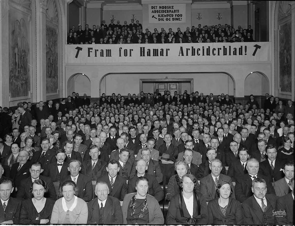 Hamar, Strandgata 23, Festiviteten, avisa Hamar Arbeiderblad feierer 10 års jubileum, banner: "Fram for Hamar Arbeiderblad"
Partiformann i Arbeiderpartiet Oscar Torp og statsråd Fredrik Monsen holdt festtalene. Det ble vist film om arbeiderbevegelsens frammarsj der en del av opptakene var gjort i Hamar Arbeiderblads lokaler, teatersalen fullt av folk,