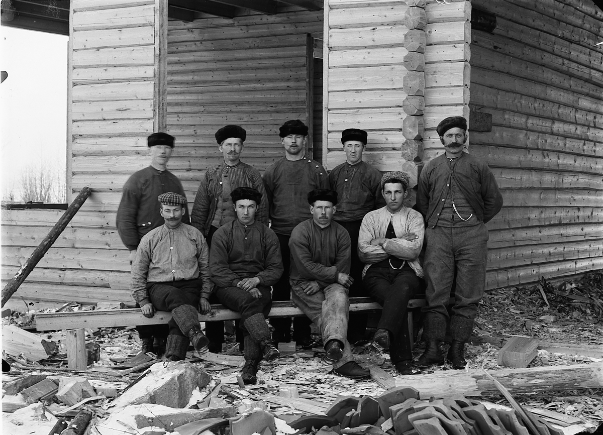 Snekkerlaget til Martin Dæhlin (1858-1937) fra Helgøya i Ringsaker. Dæhlin står ytterst til høyre. Ved siden av ham står Karl Slåtten sittende til venstre er Hilmar Solbakken f.1885, de andre er ukjent. Lafting av hus, antagelig Årengen skole på Nes, 1901.