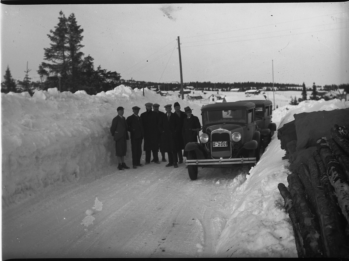 Ringsaker, Ringsakfjellet, Sjusjøen, en grupe 7 journalister, høye brøytekanter, en bil Ford A 1930 modell. I Norges Bilbok 1935 står D-2001 som Ford 1930 personbil registrert på Ole Bjørsrud, Lismark.